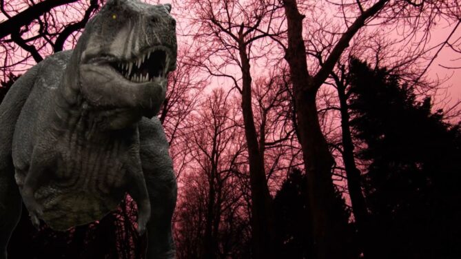 An animatronic T-Rex in a forest. The sky is a pink-tinted red.